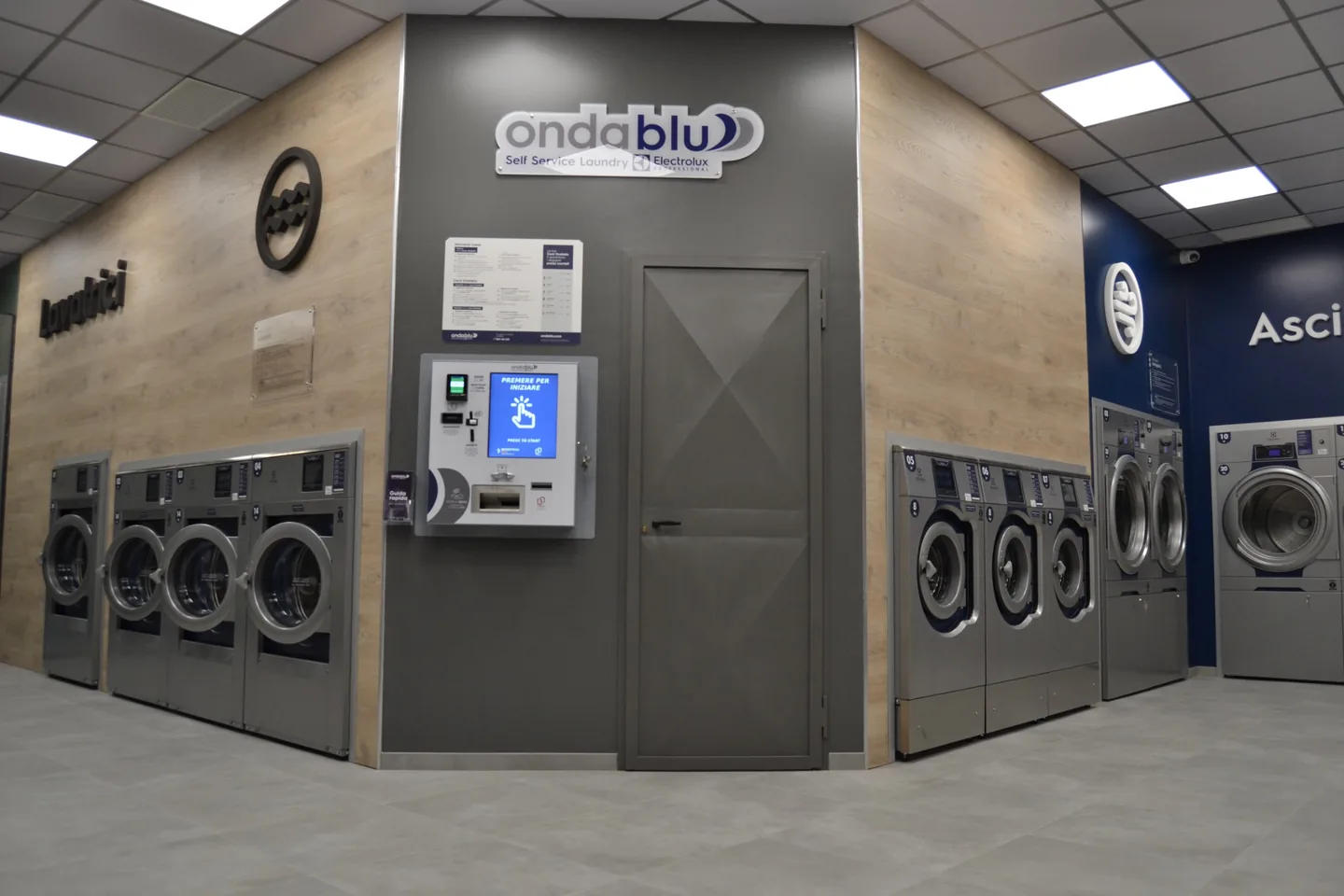 Interno della lavanderia self-service OndaBlu Avellino con lavatrici e asciugatrici Electrolux Professional
